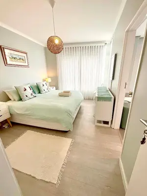 a bedroom with a bed and a large window at 706 Portico in Cape Town