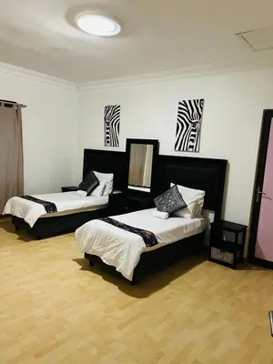 a room with three beds in it with zebra drawings on the wall at African Haven Guest House in Cape Town