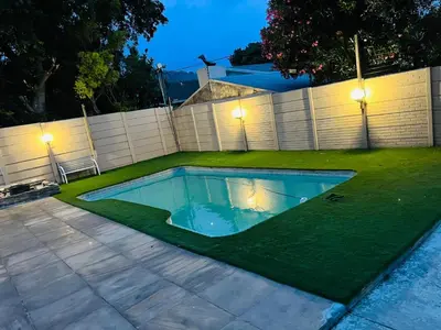 a swimming pool in a yard with green grass at African Haven Guest House in Cape Town