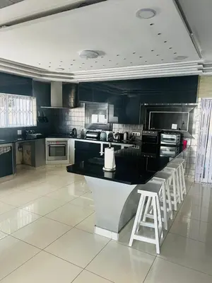 a large kitchen with a black counter and stools at African Haven Guest House in Cape Town