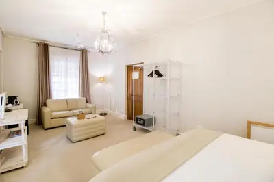 a bedroom with a bed and a couch and a chair at Harbour House Hotel - Adventure Pads in Hermanus