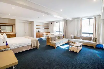 a hotel room with a bed and a living room at Harbour House Hotel - Adventure Pads in Hermanus