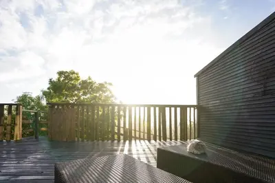 a deck with a bench and a wooden fence at Avemore Vineyard View - wood fired hot tub and full power back up in Onder-Papegaaiberg