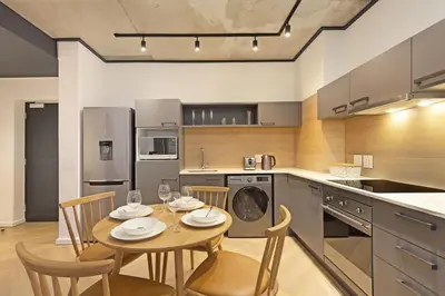 a kitchen with a table and chairs in a kitchen at Bridgewater View 502 in Cape Town