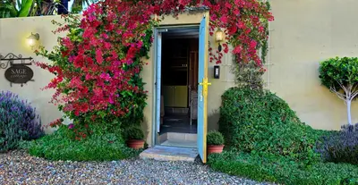 a house with flowers on the side of it at SAGE Cottage Bloubergstrand in Cape Town