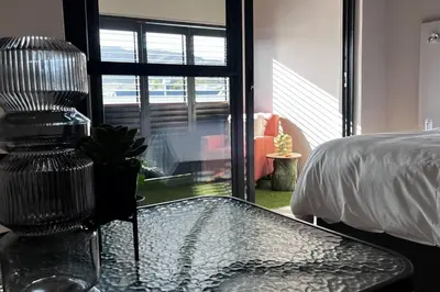 a glass table with a chair in a bedroom at Hermanus Waterfront Apartment No.19 in Hermanus
