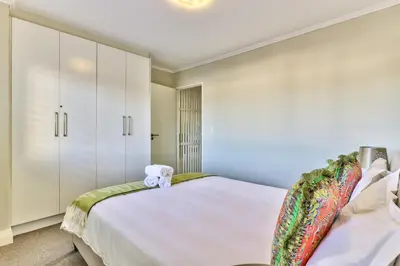 a bedroom with a bed with a teddy bear on it at 2 Bedroom Apartment in Century City 204QS in Cape Town