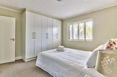 a bedroom with a white bed and a window at 2 Bedroom Apartment in Century City 204QS in Cape Town