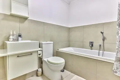 a bathroom with a toilet and a bath tub at 2 Bedroom Apartment in Century City 204QS in Cape Town