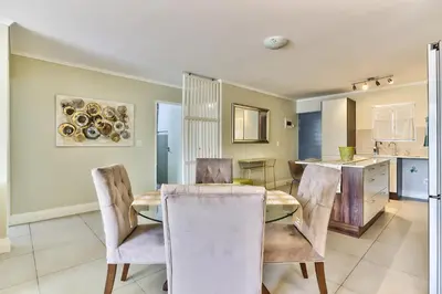 a kitchen and dining room with a table and chairs at 2 Bedroom Apartment in Century City 204QS in Cape Town