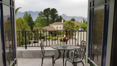a table and chairs on a balcony with a view at Mountain View Self-Catering Apartments in Somerset West
