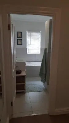 a hallway leading to a bathroom with a window at Mountain View Self-Catering Apartments in Somerset West