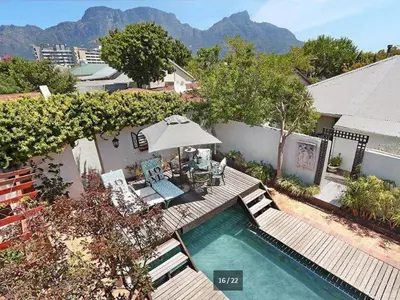 an overhead view of a swimming pool with chairs and an umbrella at Harfield Guest Villa in Cape Town