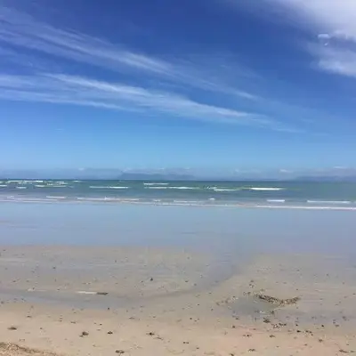 a view of the beach with the ocean in the background at Beachfront Gem / Free Parking / A/C in Cape Town