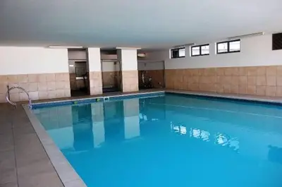 a large swimming pool with blue water in a building at Beachfront Gem / Free Parking / A/C in Cape Town