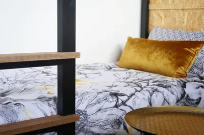 a bedroom with a bed with a pillow and a chair at Quiet hidden gem in historic Stellenbosch in Stellenbosch