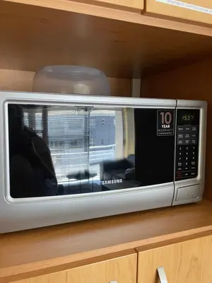 a microwave oven sitting on top of a cabinet at Blouberg Beach Luxury Apartment in Cape Town