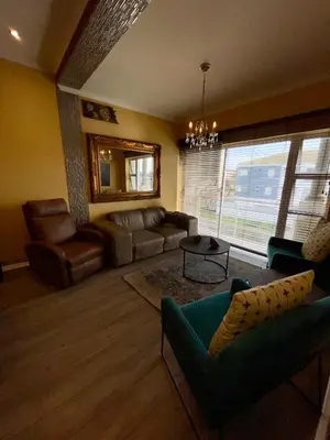 a living room with a couch and a table at Blouberg Beach Luxury Apartment in Cape Town