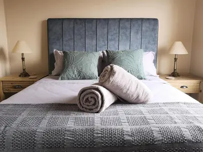 a bedroom with a bed with towels on it at Blouberg Beach Luxury Apartment in Cape Town