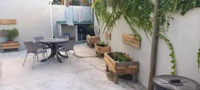a patio with a table and chairs and a tree at Bing Heights Suite in Hermanus