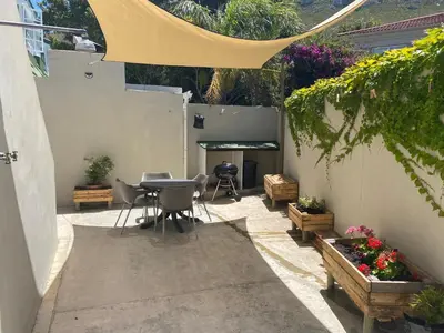 a patio with a table and chairs and a grill at Bing Heights Suite in Hermanus