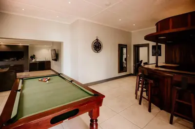 a room with a pool table and a bar at Villa Visser in Cape Town
