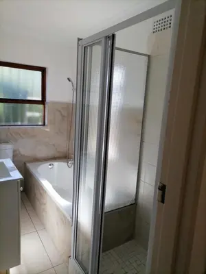 a bathroom with a shower and a bath tub at Capetown Adilo Villa in Cape Town