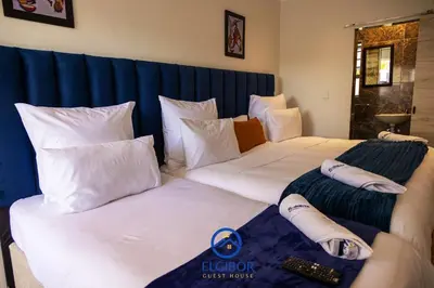 two beds in a hotel room with white pillows at El-Gibor Best Guest House in Cape Town