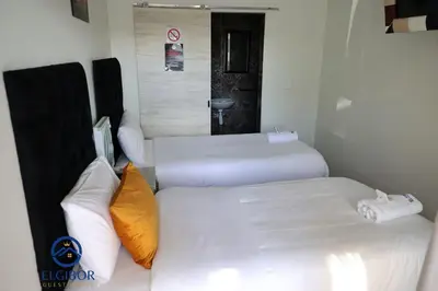 a hotel room with two beds and a couch at El-Gibor Best Guest House in Cape Town
