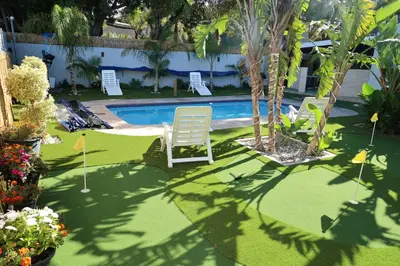 a yard with a pool with chairs and a table at El-Gibor Best Guest House in Cape Town