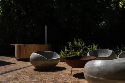a group of bowls and tables on a brick patio at Avemore Winelands Home - wood fired hottub and full power back up in Stellenbosch