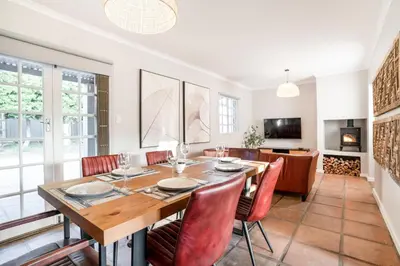 a dining room with a wooden table and chairs at Avemore Winelands Home - wood fired hottub and full power back up in Stellenbosch
