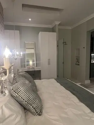 a bedroom with a large bed with two pillows on it at Two on Milner - OAK TREE COTTAGE - Stylish open-plan Guesthouse in Rondebosch in Cape Town