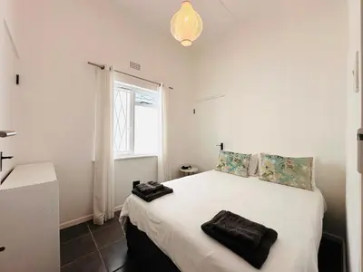 a bedroom with a large white bed with a window at 2-Bedroom Hermanus - Sleeps 4 - Near Sea in Hermanus