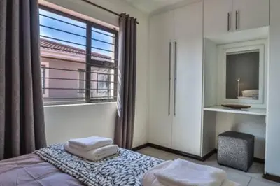 a bedroom with a bed and a large window at Howard Davis 28B by CTHA in Cape Town