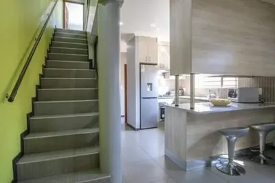 a kitchen with a staircase and a kitchen with a counter at Howard Davis 28B by CTHA in Cape Town