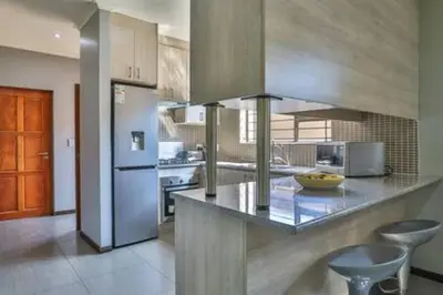 a kitchen with a counter and a refrigerator at Howard Davis 28B by CTHA in Cape Town