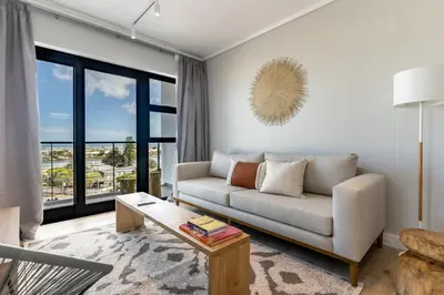 a living room with a couch and a table at Burmeister 401 - 2 Bedroom Apartment across from Ocean - Onsite Parking in Cape Town