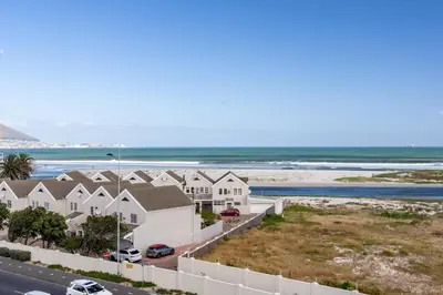 an aerial view of a row of houses next to the beach at Burmeister 401 - 2 Bedroom Apartment across from Ocean - Onsite Parking in Cape Town