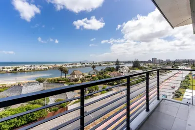 a balcony with a view of the beach at Burmeister 607 - Top Floor Corner 2 Bedroom Apartment with Sea and Lagoon Views - Onsite Parking in Cape Town