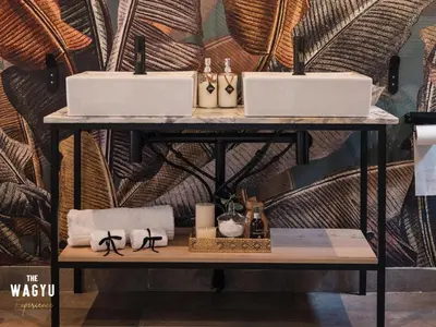 a table with two sinks in a room with a wall at Wagyu Mountain Lodge in Paarl