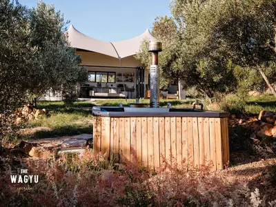a hot tub in the yard of a house at Wagyu Mountain Lodge in Paarl