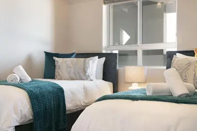 a bedroom with two beds and a window at Sea Spray B404 in Cape Town