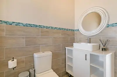 a bathroom with a white toilet and a mirror at Sea Spray B404 in Cape Town