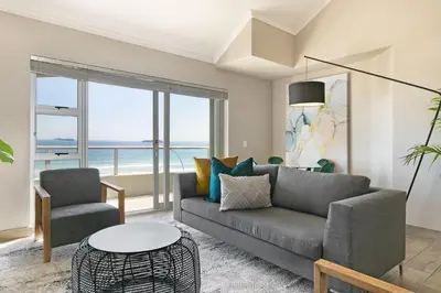 a living room with a couch and a table at Sea Spray B404 in Cape Town