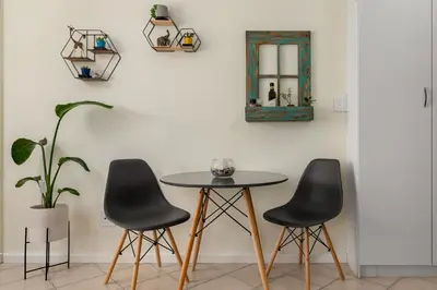 a table and two chairs in a room with a mirror at Ocean View B201B in Cape Town