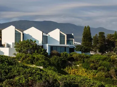 a house on a hill with mountains in the background at Boutique Ocean Views - incorporating Wendy's in Hermanus