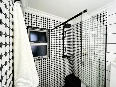 a bathroom with a glass shower with a window at Luxurious 2-bedroom beach apartment with a view! in Bloubergstrand