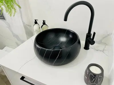 a black bowl sitting on a counter next to a sink at Luxurious 2-bedroom beach apartment with a view! in Bloubergstrand