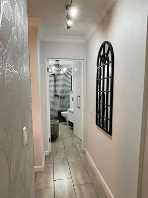 a hallway with a bathroom with a toilet and a mirror at Luxurious 2-bedroom beach apartment with a view! in Bloubergstrand